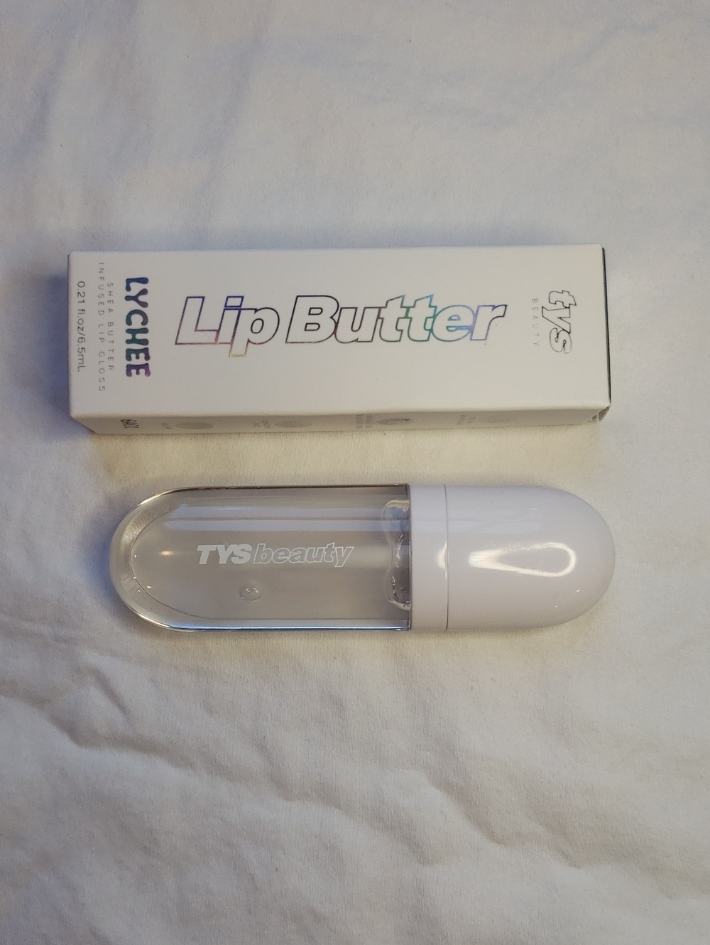 Lychee scented clear shea butter lip gloss.  TYS Beauty brand